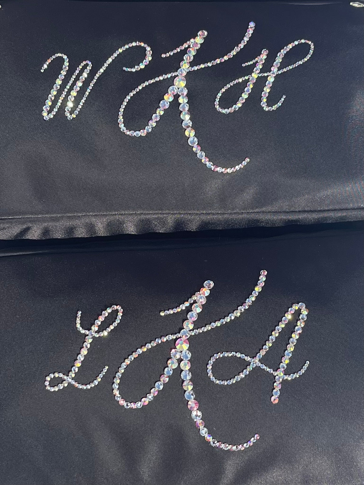 wedding favors gifts for bride and bridesmaids black cosmetics bags with monogram rhinestone-embellished initials 'WFH' and 'LFA'.