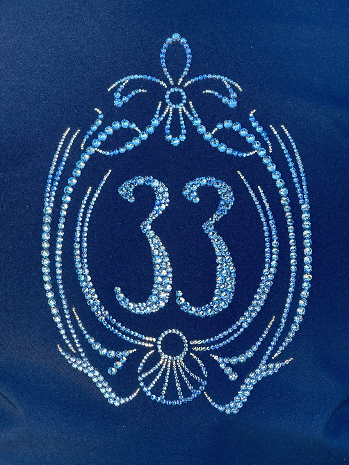 Decorative number '33' made with Looking Glass Gems rhinestone embellishments on a blue background from Club 33 logo Disney Disneyland