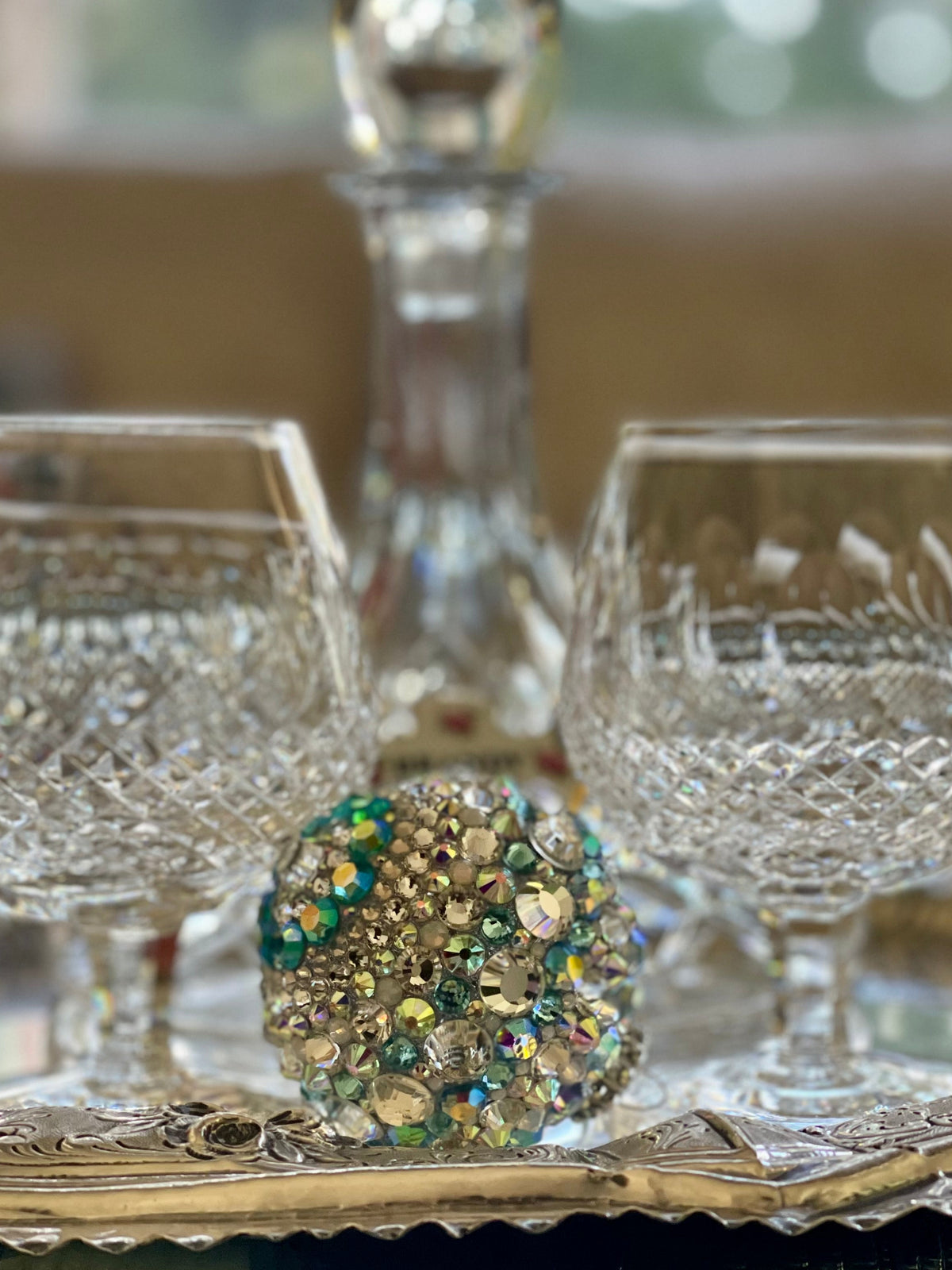 Crystal decanter and glasses on a silver tray with decorative gemstone ball, hand embellished by Looking Glass Gems.